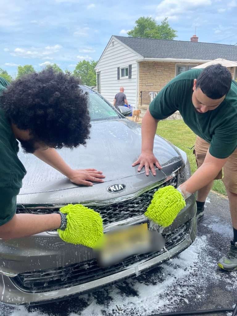 The HH Premium Services team hand-washing a Kia with precision during a mobile detailing service in Plainfield, NJ - Proudly Serving Plainfield & Central New Jersey - Learn More About HH Premium Services